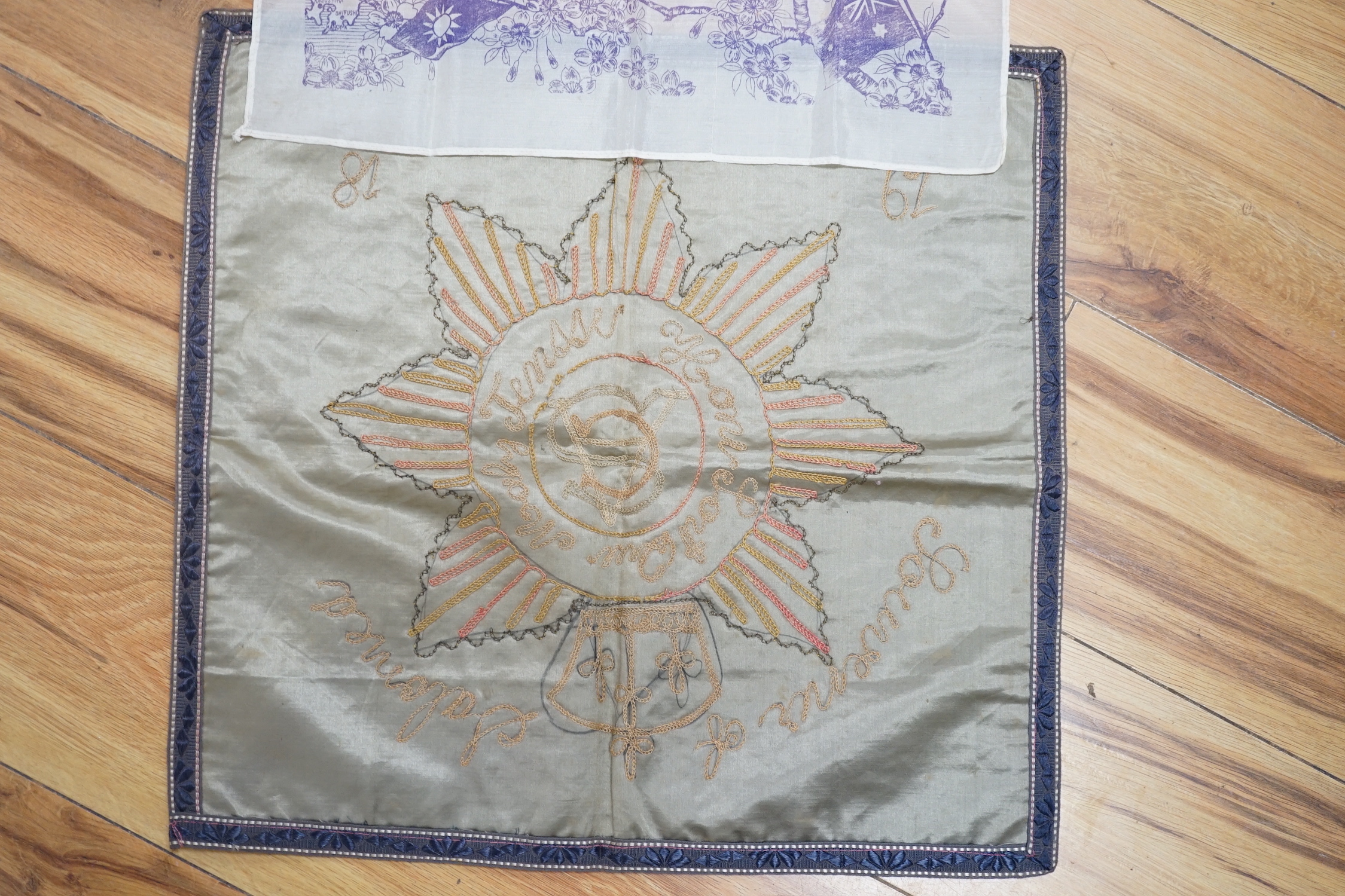 A WWII silk printed handkerchief; ‘Nippon Times’ commemorating the surrender of the Japanese, together with a WWI Army Service Corps emblem dated 1918, 44 x 45cm